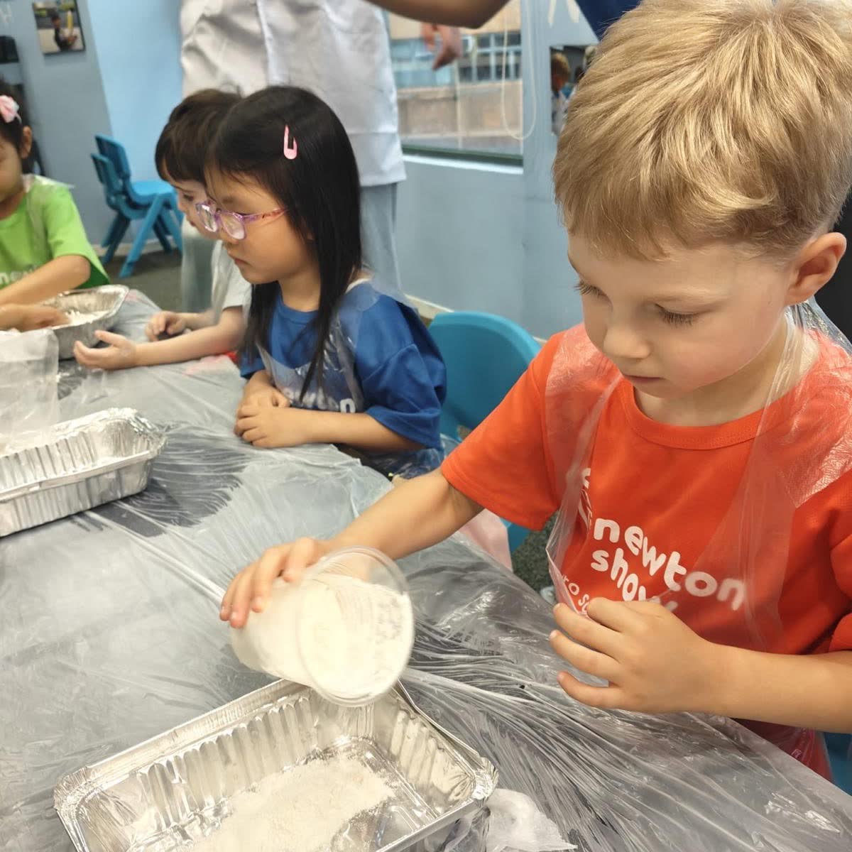 Children working through hands-on science trays together at a Newtonshow holiday camp